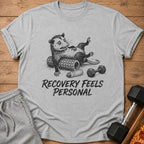 Opossum lying on a foam roller with dumbbells and text "RECOVERY FEELS PERSONAL".