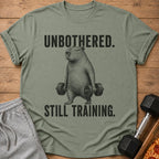 T-shirt with capybara lifting weights and text "UNBOTHERED. STILL TRAINING."