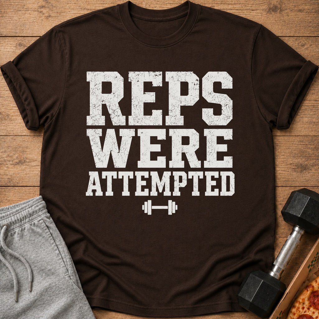 Brown t-shirt with distressed white text "REPS WERE ATTEMPTED" and dumbbell icon.