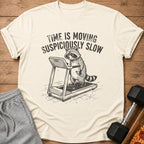 T-shirt with raccoon on treadmill and text "TIME IS MOVING SUSPICIOUSLY SLOW".