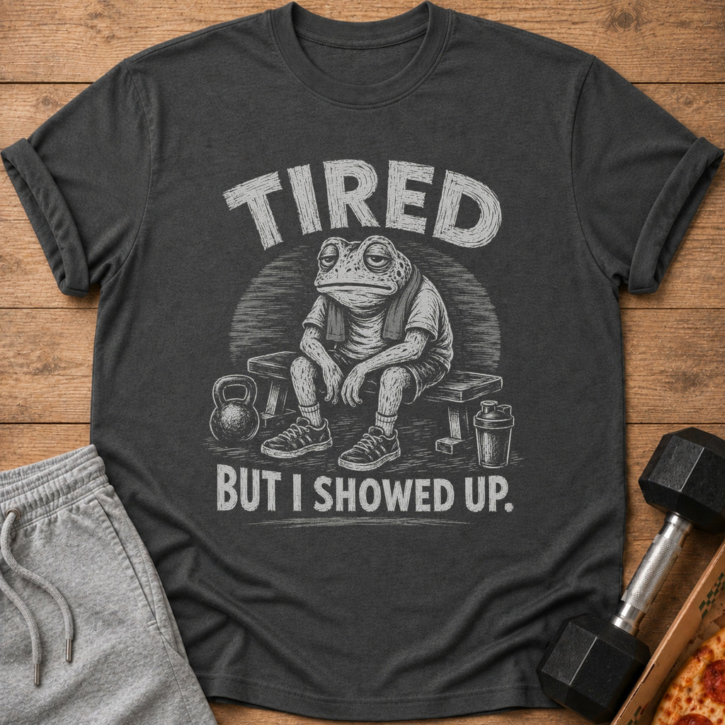 Dark t-shirt with distressed graphic of a tired frog on a bench with weights and text "TIRED BUT I SHOWED UP."