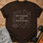 Brown t-shirt with gym illustrations and text: "NOT PEAKING. JUST PARTICIPATING."