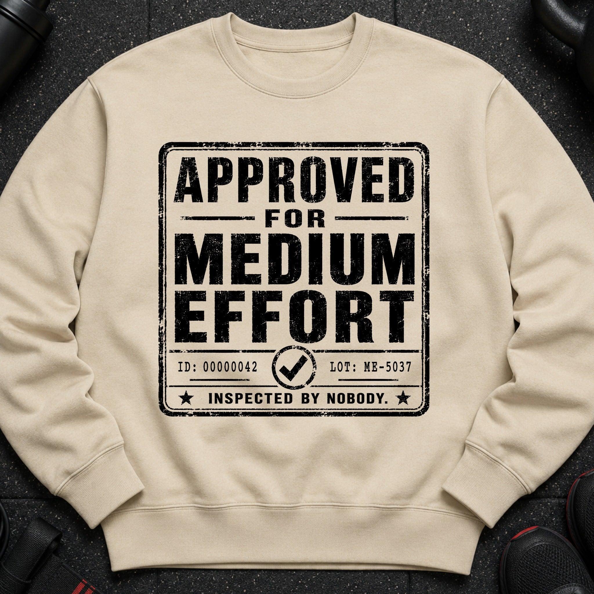 Tan sweatshirt with distressed black text: "APPROVED FOR MEDIUM EFFORT".