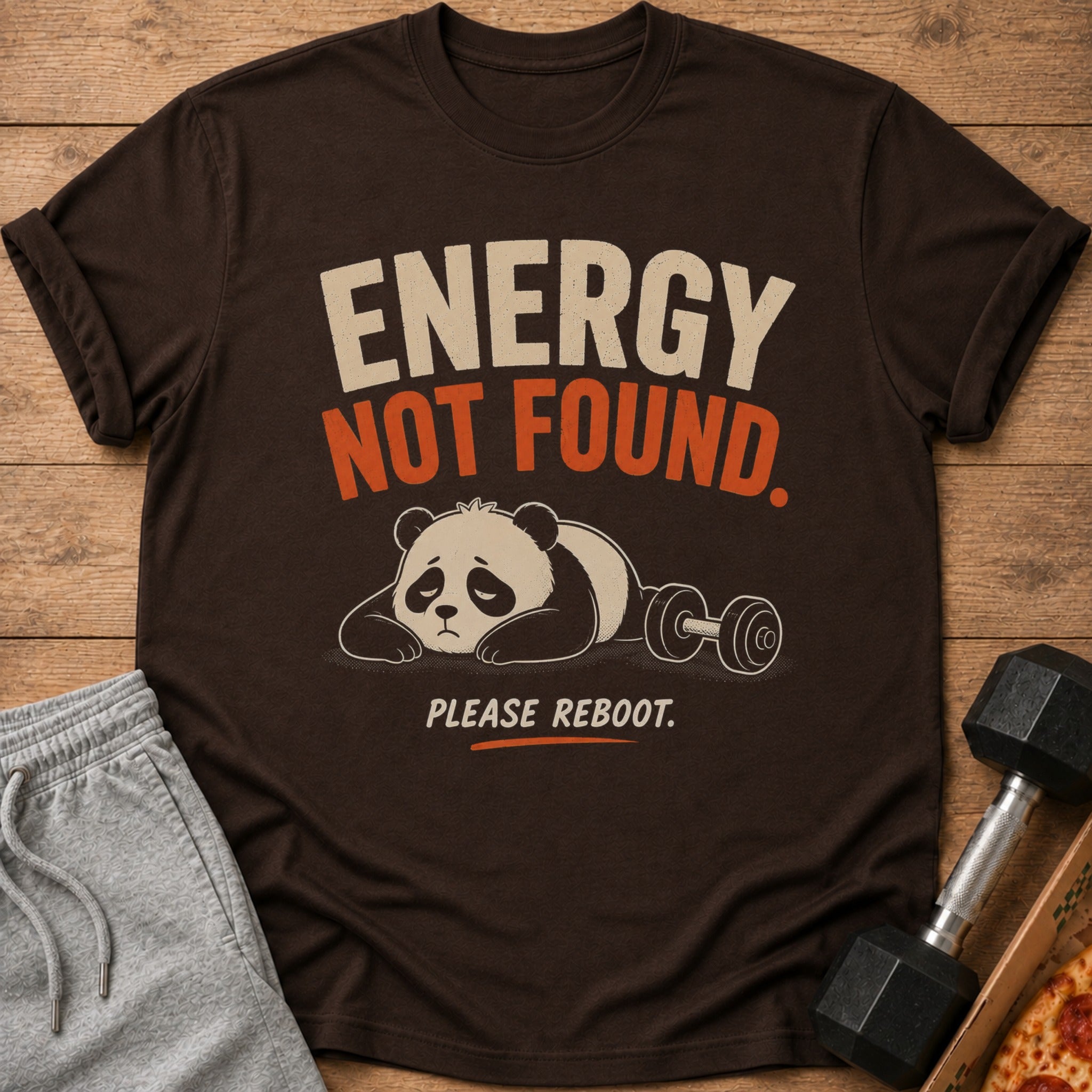 Brown t-shirt with text "ENERGY NOT FOUND. PLEASE REBOOT." and a sad panda with a dumbbell.