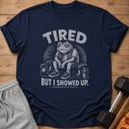 Dark blue t-shirt with text "TIRED BUT I SHOWED UP." and frog graphic.