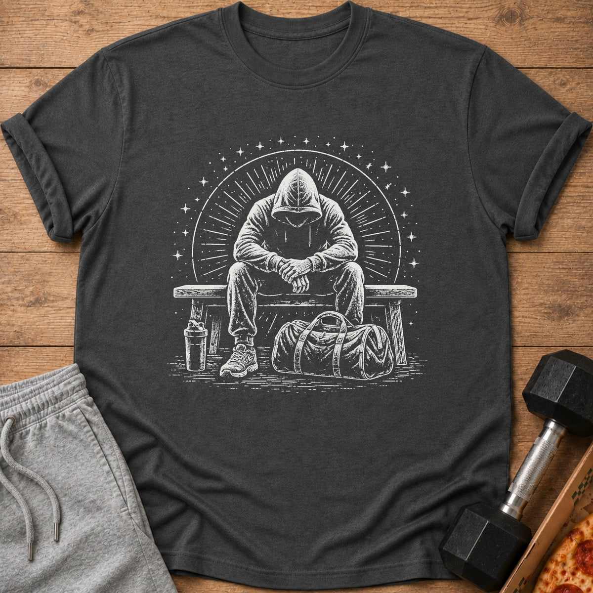 T-shirt with graphic of person in hoodie sitting on bench with gym bag.