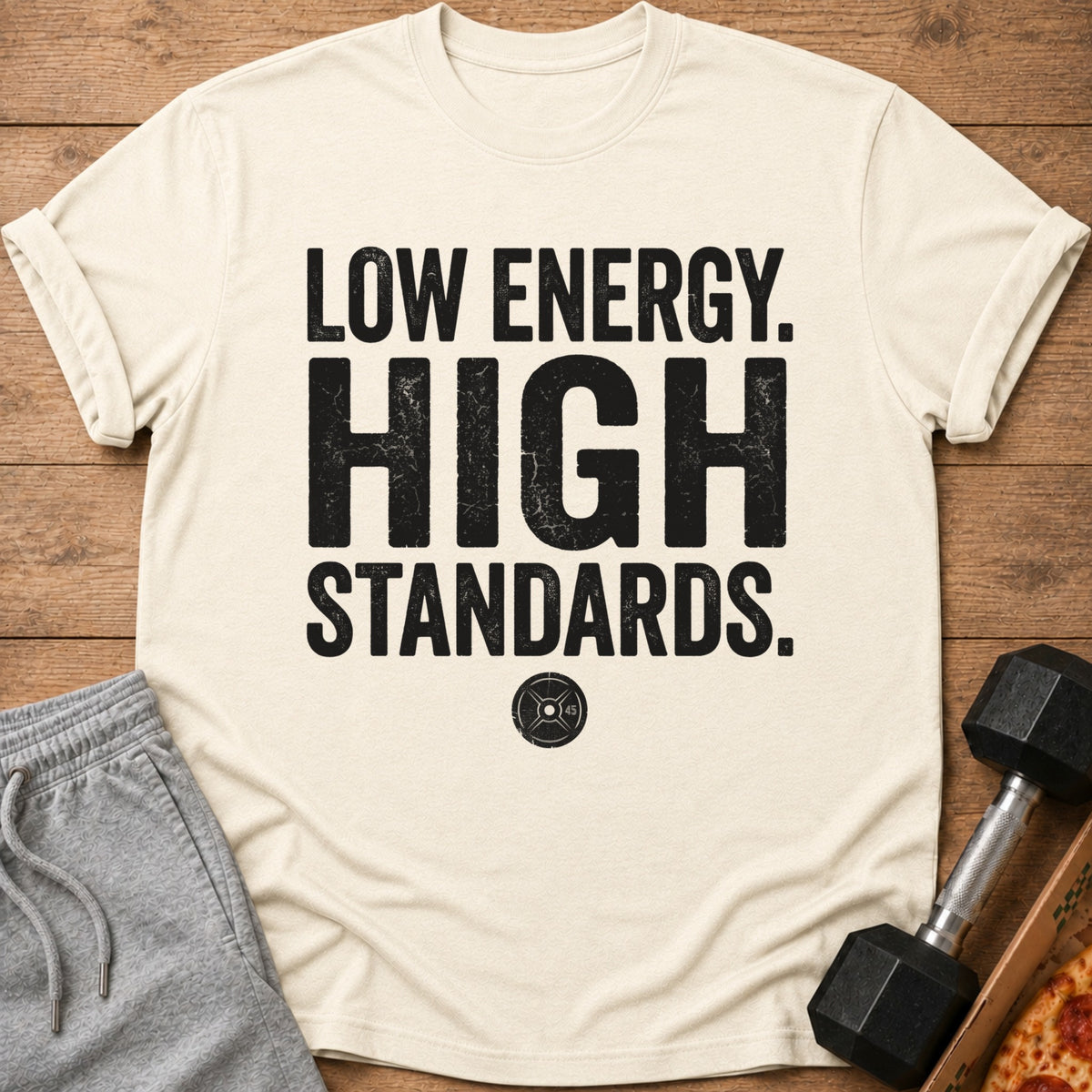 Cream t-shirt with "LOW ENERGY. HIGH STANDARDS." text and a weight plate graphic.