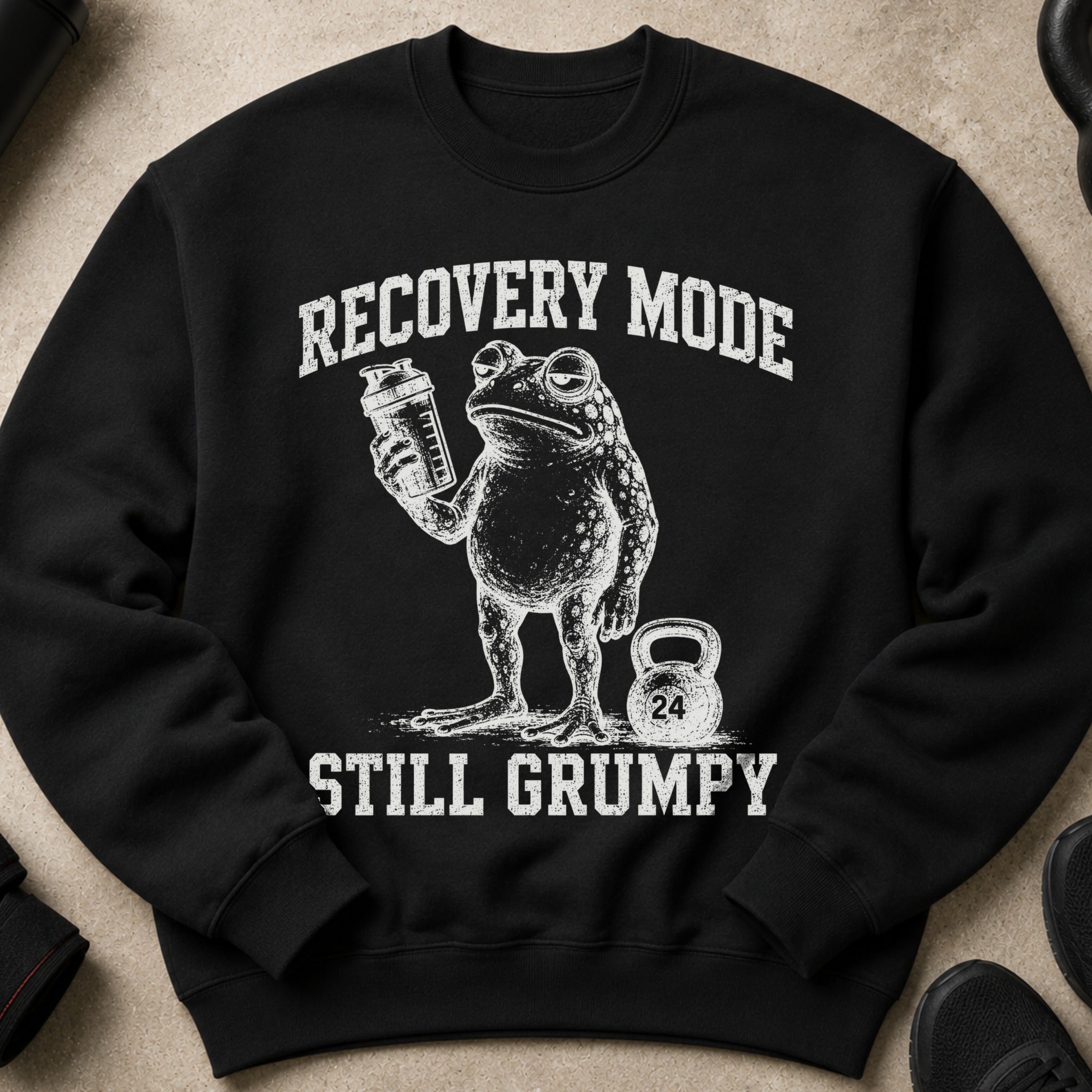 Black sweatshirt with frog holding a shaker bottle and text "RECOVERY MODE STILL GRUMPY".