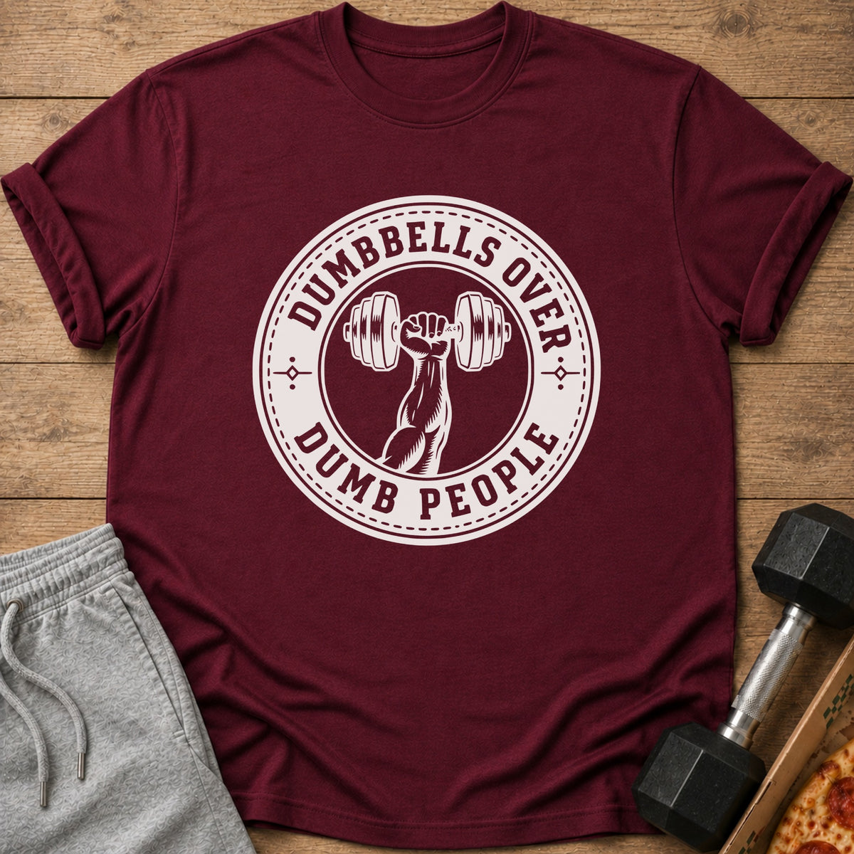 Maroon t-shirt with white "Dumbbells Over Dumb People" graphic featuring a dumbbell.