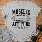 Gray t-shirt with "Muscles Loading. Attitude Ready." text and dumbbell graphic.