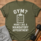 Olive green t-shirt with text "GYM? MORE LIKE A MANDATORY APPOINTMENT".