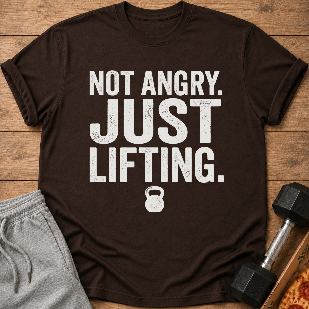 Brown t-shirt with distressed white text "NOT ANGRY. JUST LIFTING." and a kettlebell icon.