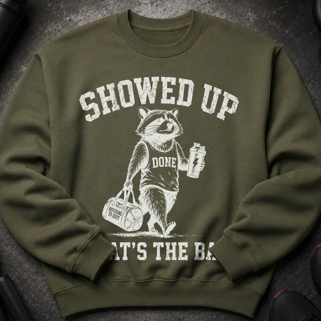 Green sweatshirt with distressed graphic of a raccoon holding a gym bag and shaker.