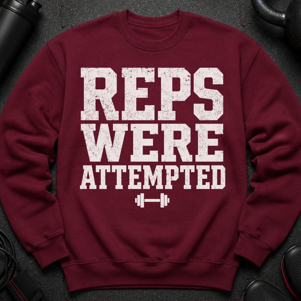 Maroon sweatshirt with graphic text "REPS WERE ATTEMPTED" and barbell.