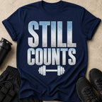 Navy t-shirt with "STILL COUNTS" text and barbell graphic.