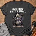 T-shirt with text "OVERTHINK. STRETCH. REPEAT." and a possum tangled in string.