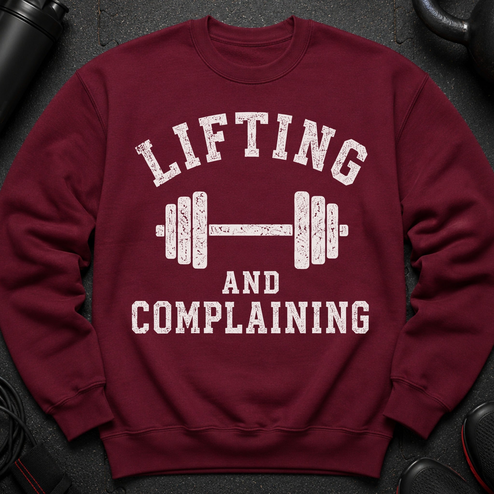 Maroon sweatshirt with white text "Lifting and Complaining" and a dumbbell design.