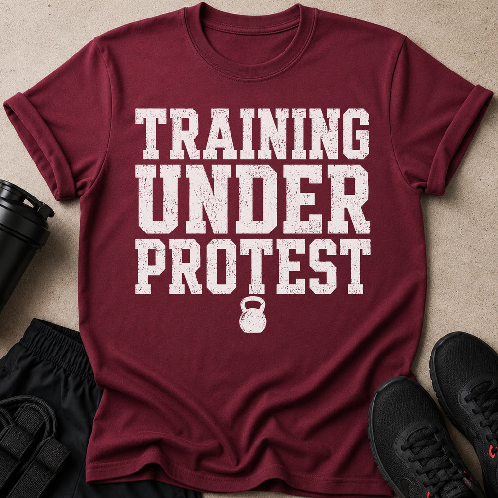 Maroon t-shirt with distressed white text "TRAINING UNDER PROTEST" and kettlebell graphic.