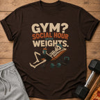 Brown t-shirt graphic with skeleton on bench, text "Gym? Social Hour With Weights."