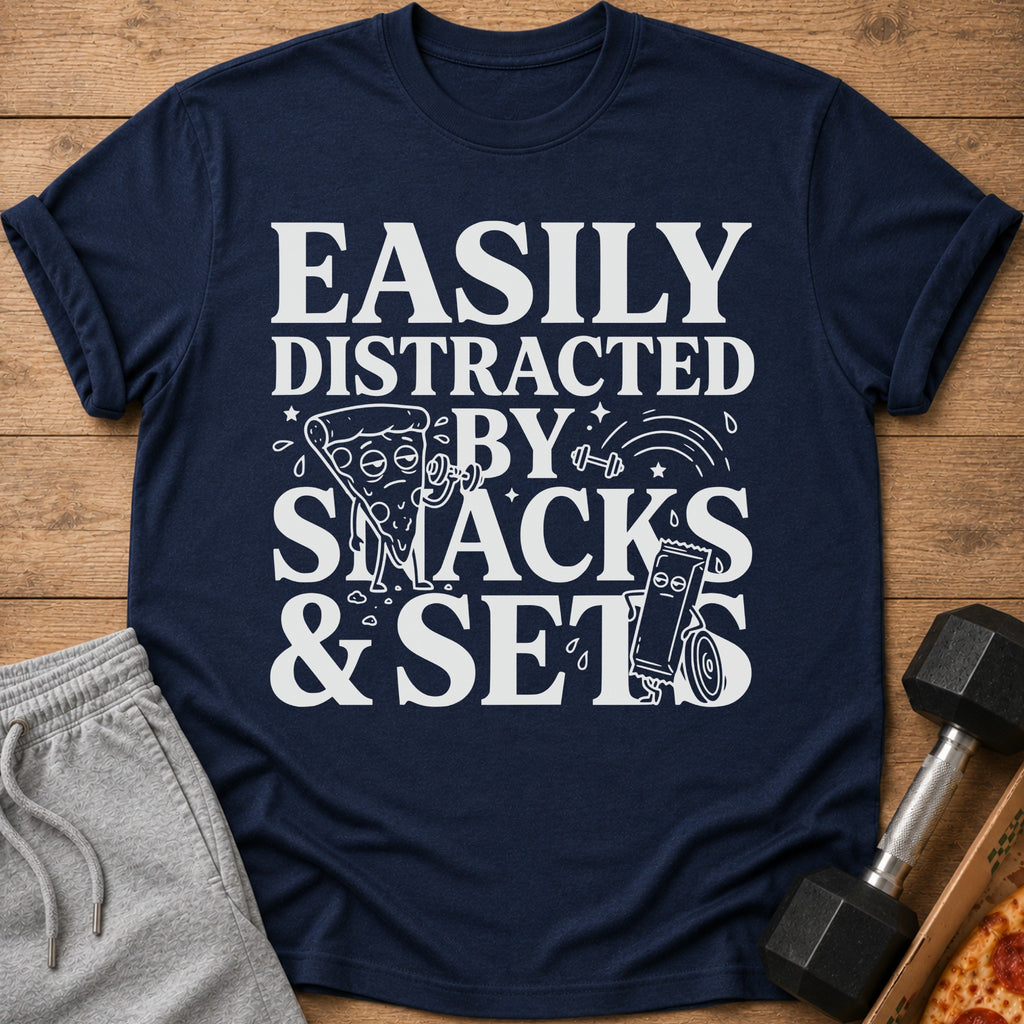Navy t-shirt with white text and graphics reading "Easily Distracted By Snacks & Sets".
