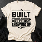 Cream t-shirt with black text "Built for mostly showing up"