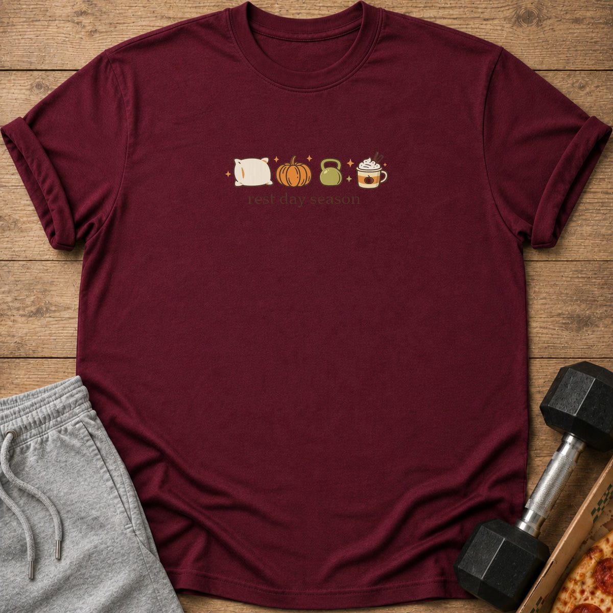 Maroon t-shirt with pillow, pumpkin, kettlebell, and coffee graphics and "rest day season" text.
