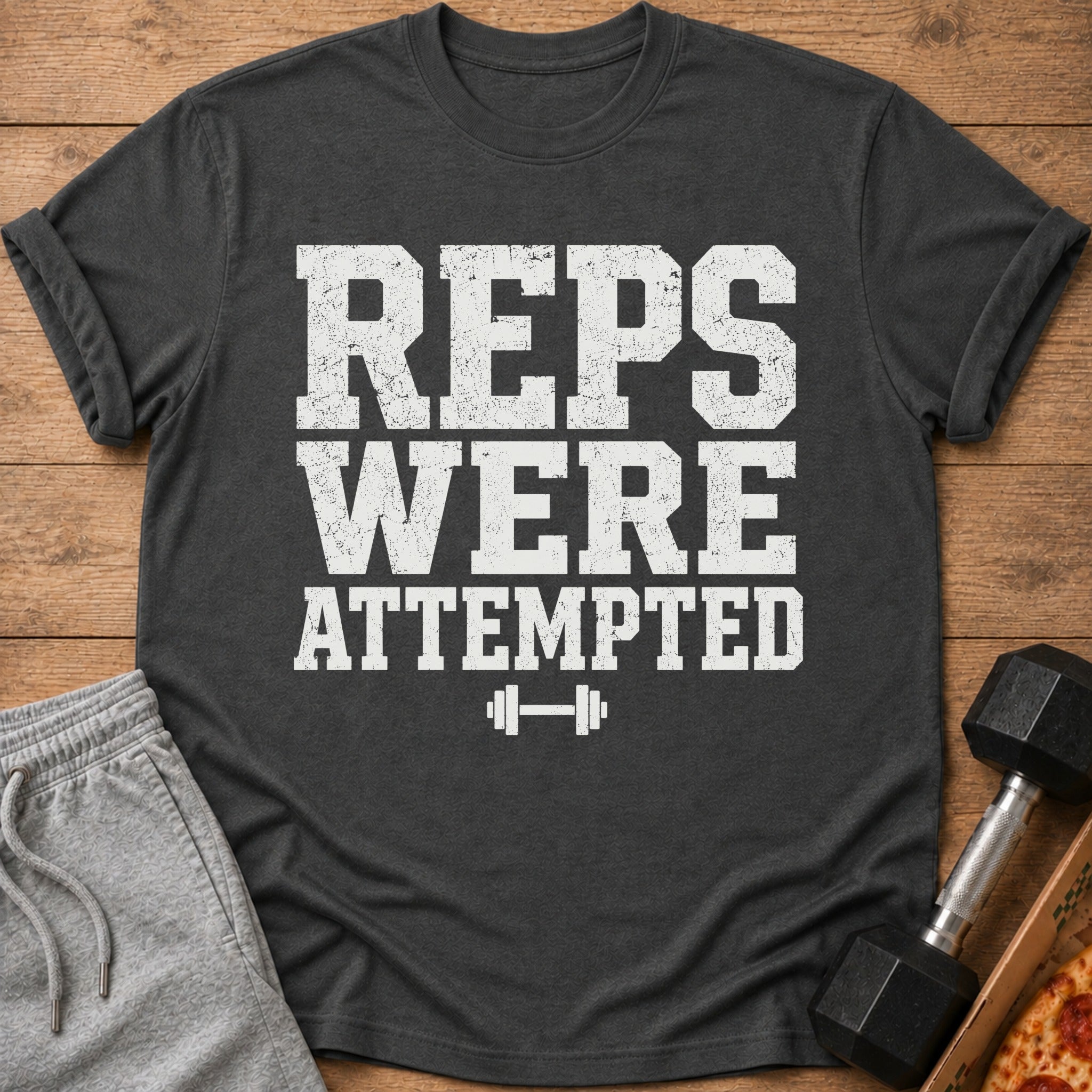 Dark grey t-shirt with white text "REPS WERE ATTEMPTED" and a dumbbell icon.