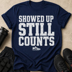 Navy t-shirt with white distressed text "SHOWED UP STILL COUNTS" and a sneaker graphic.