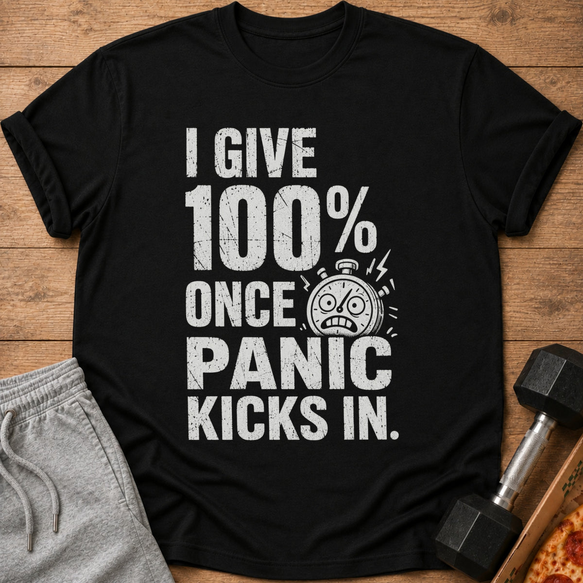 Black t-shirt with text "I GIVE 100% ONCE PANIC KICKS IN." and a stopwatch graphic.