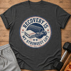 Dark grey t-shirt graphic: "Recovery is my strongest lift. Rest reps count."