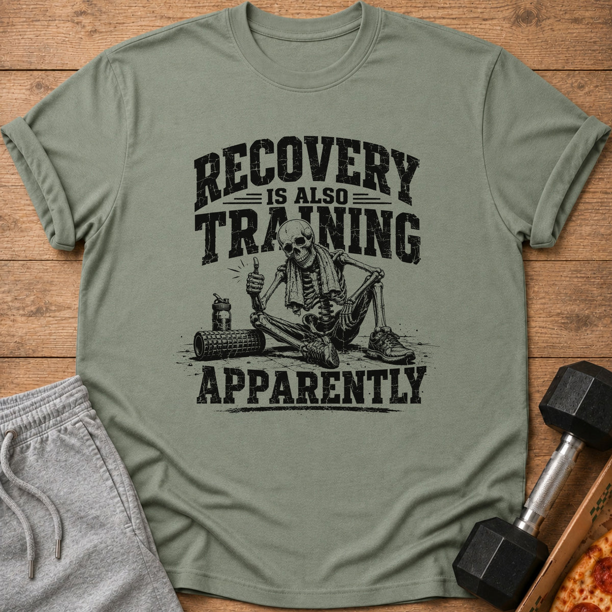 Green t-shirt with skeleton graphic and text "RECOVERY IS ALSO TRAINING APPARENTLY".