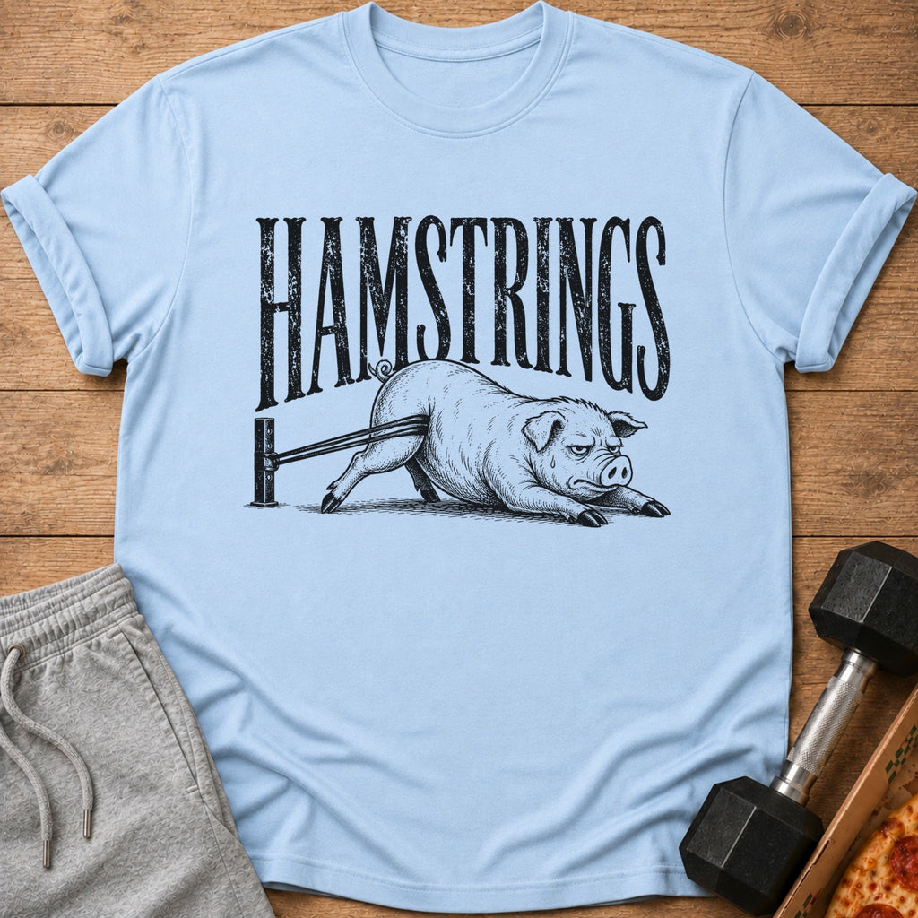 Light blue t-shirt with black text "HAMSTRINGS" above a pig stretching on a resistance band.