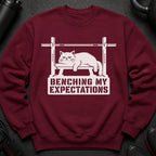 Maroon sweatshirt with a white graphic of a cat on a bench press and text.