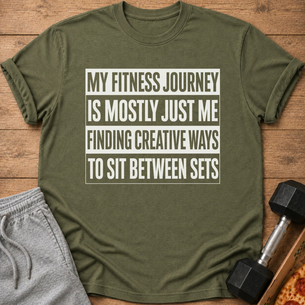 Olive green t-shirt with text "My fitness journey is mostly just me finding creative ways to sit between sets."