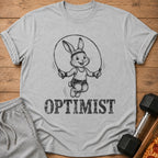 Grey t-shirt with a graphic of a rabbit jumping rope and the word OPTIMIST.