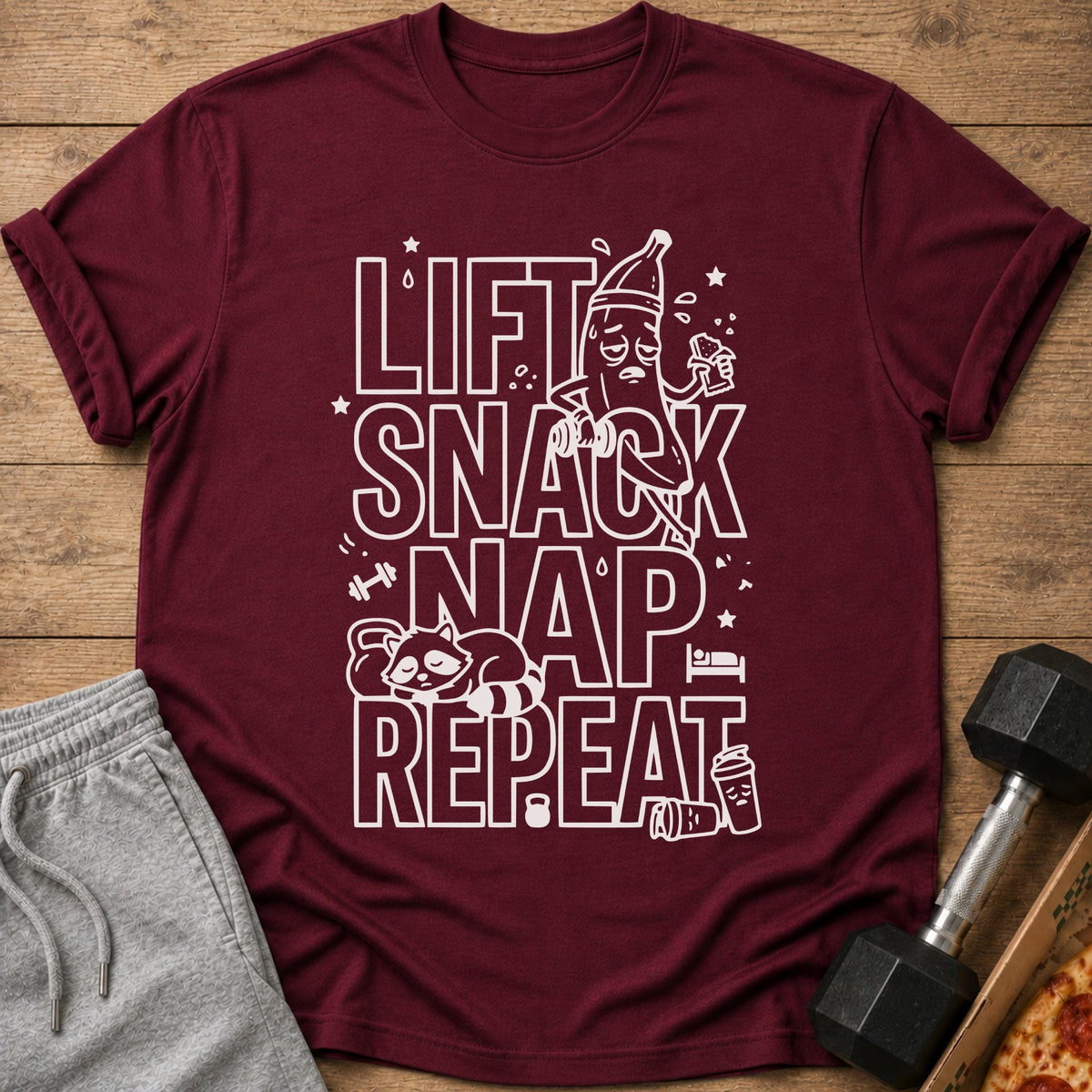 Maroon t-shirt with white text "LIFT SNACK NAP REPEAT" and graphic elements.