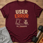 Maroon t-shirt with "USER ERROR TRY TOMORROW" text and cartoon.