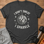 Dark grey t-shirt with "I DON'T SWEAT I SPARKLE" and disco ball graphic.