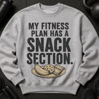 Grey sweatshirt with text "MY FITNESS PLAN HAS A SNACK SECTION" and a plate of banana, cookie, and protein bar.