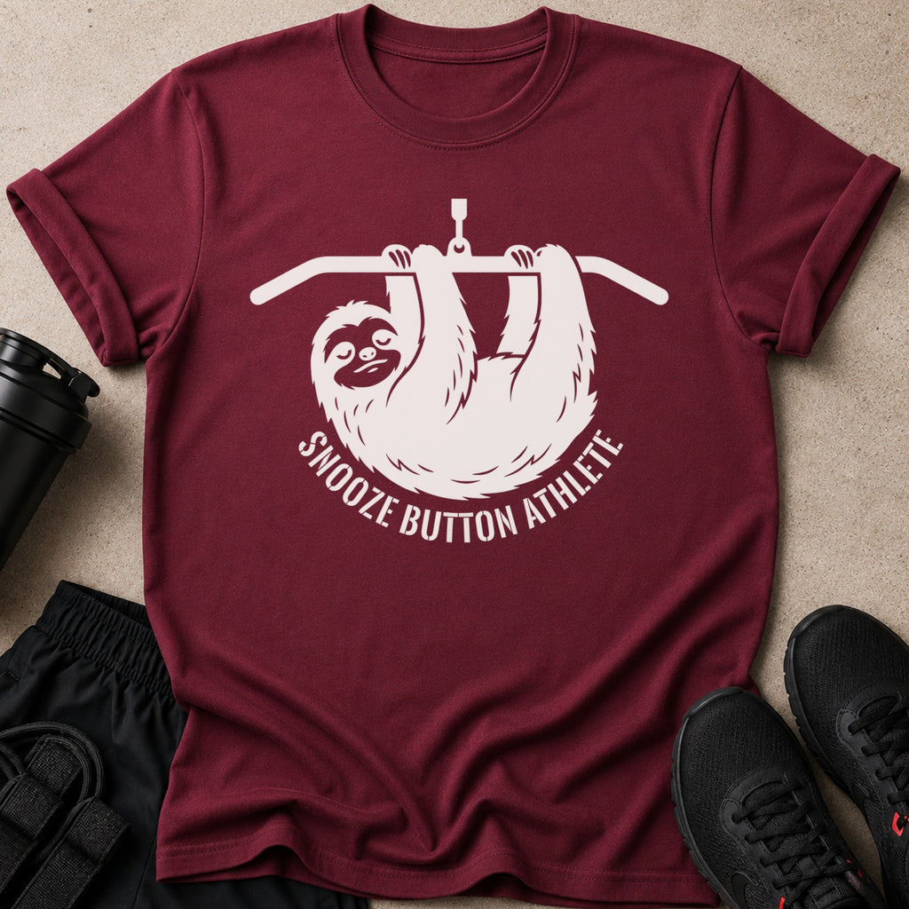 Maroon t-shirt with white graphic of a sloth hanging from a pull-up bar and text: Snooze Button Athlete.