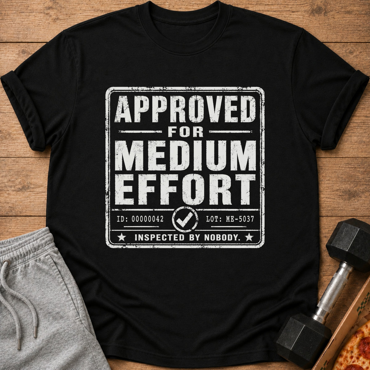 Black t-shirt with "APPROVED FOR MEDIUM EFFORT" text and "INSPECTED BY NOBODY."