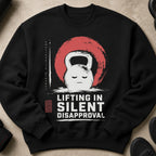 Black sweatshirt with a grumpy kettlebell graphic and text that reads "Lifting in Silent Disapproval".