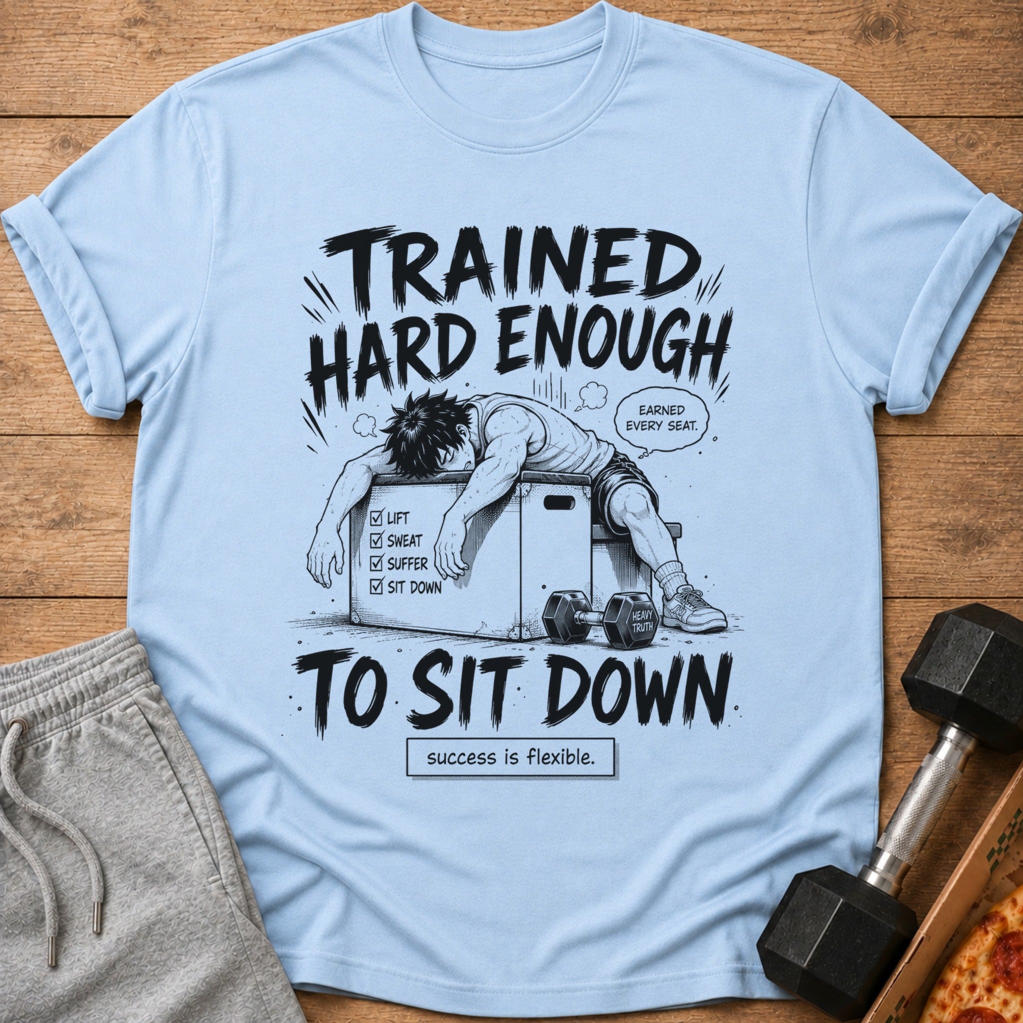 Light blue t-shirt with cartoon man on workout box, "Trained Hard Enough To Sit Down".