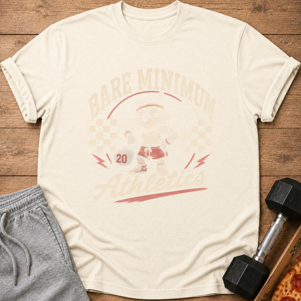 Cream t-shirt with "Bare Minimum Athletics" graphic featuring a cartoon lifting weight.