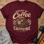 Maroon t-shirt with a bear graphic reading "Powered by Coffee Caffeine & Regret".