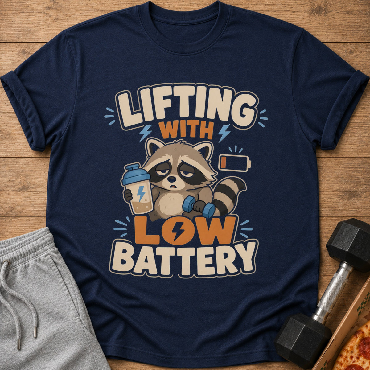 Navy t-shirt with cartoon raccoon, dumbbell, and "Lifting with Low Battery" text.