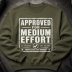 Olive green sweatshirt with "APPROVED FOR MEDIUM EFFORT INSPECTED BY NOBODY" graphic.