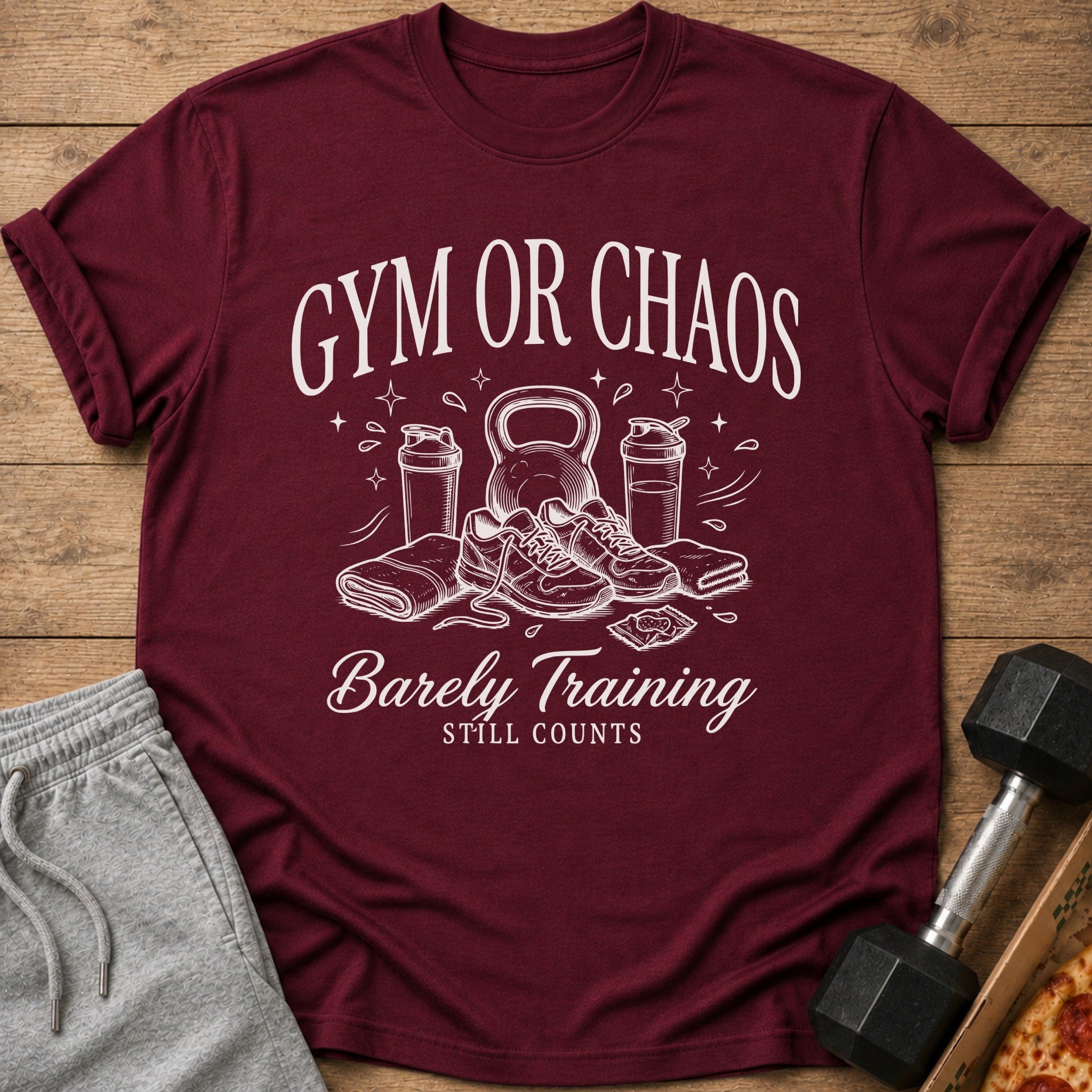 Maroon t-shirt with "Gym or Chaos, Barely Training Still Counts" graphic.