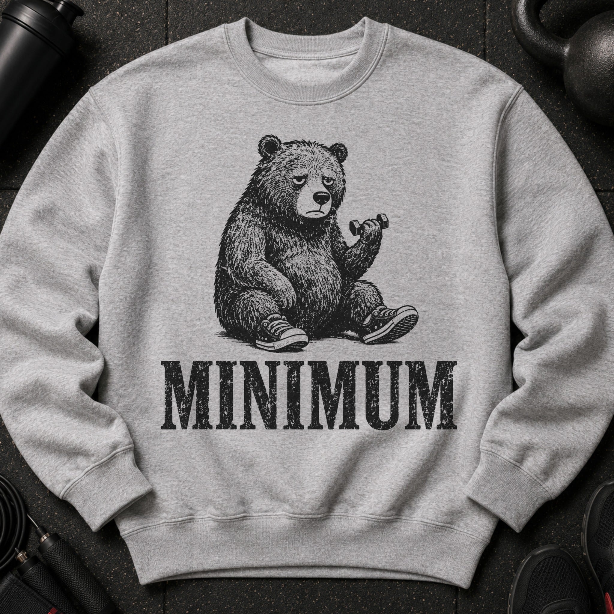 Grey sweatshirt with a graphic of a tired bear lifting a dumbbell and the word MINIMUM.