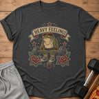 Muscular frog lifting weights with "Heavy Feelings" text on a t-shirt.